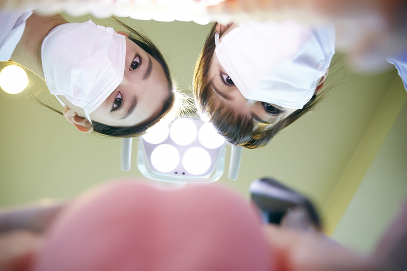 根幹治療で難しそうな顔をしている歯科医と歯科助手