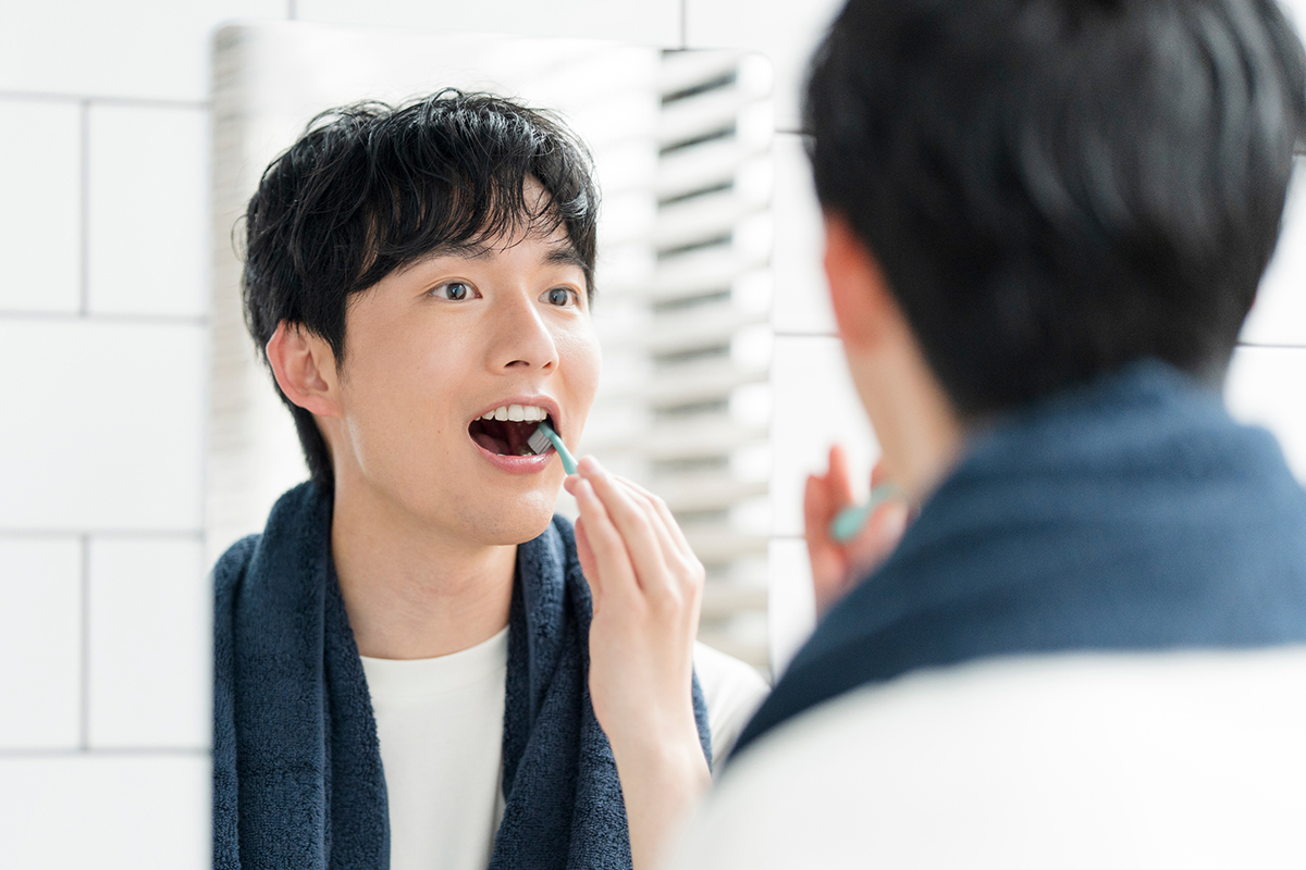 根管治療中の男性が歯磨きする様子
