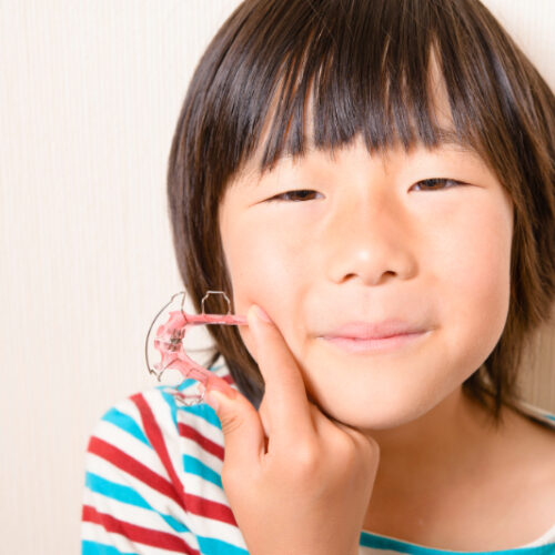 床矯正の器具を持っている子ども