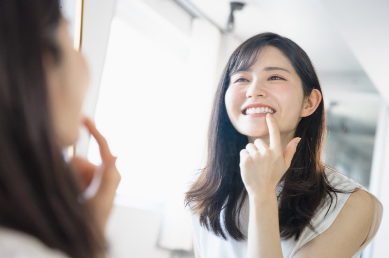 初期の歯周病の治療で綺麗になった歯茎を見て笑顔の女性の画像