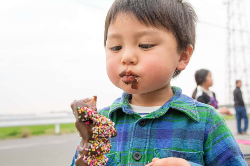 乳歯に着色しやすいチョコレートを食べる男の子