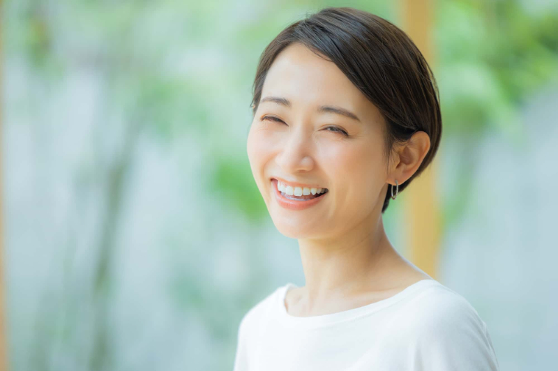 歯のクリーニングをして綺麗な白い歯で笑う女性