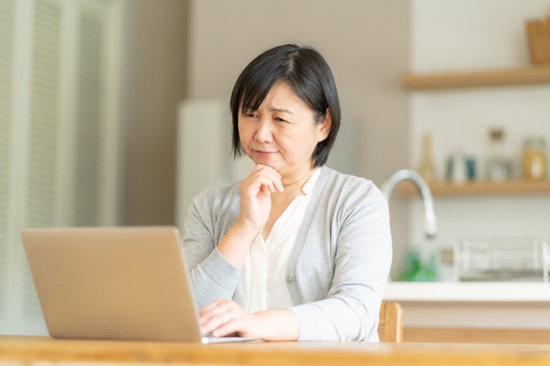 歯周病と糖尿病の関係についてパソコンで調べる女性