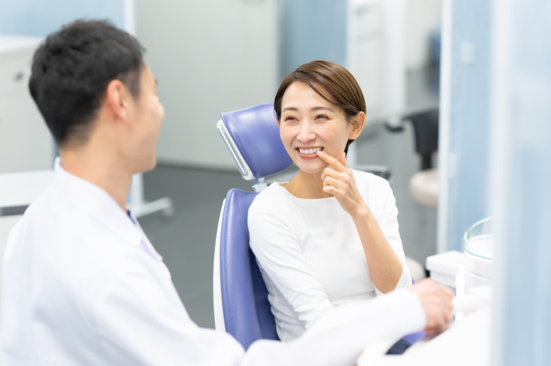 歯科医師にフッ素塗布について相談する女性