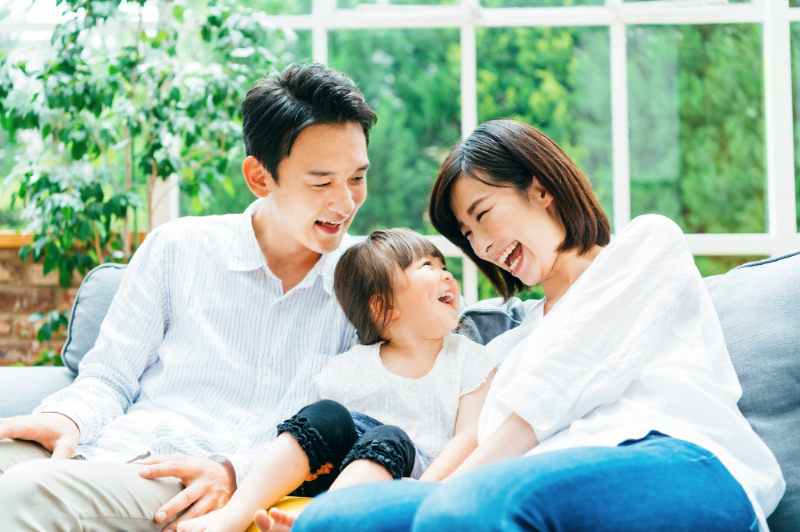 ソファで楽しそうに笑う親子