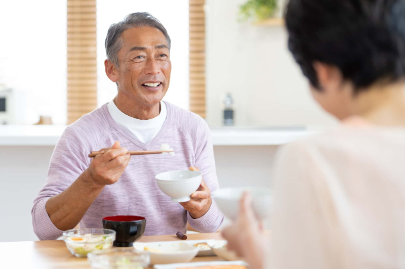 笑顔で食事をする男性