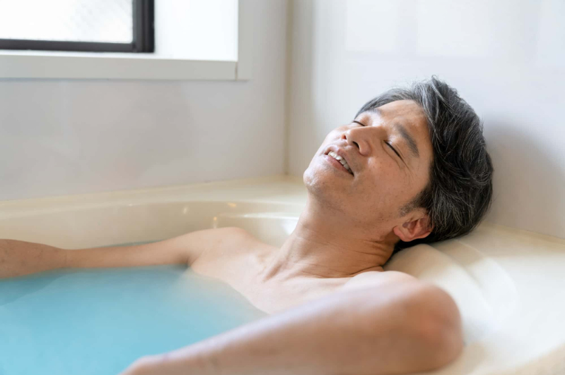 歯ぎしりを改善するために入浴で筋肉の緊張をほぐす男性