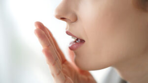 自分の口臭を確認する女性