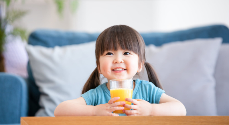 ジュースを飲んでいる仕上げ磨きで健康な歯を保っている子ども