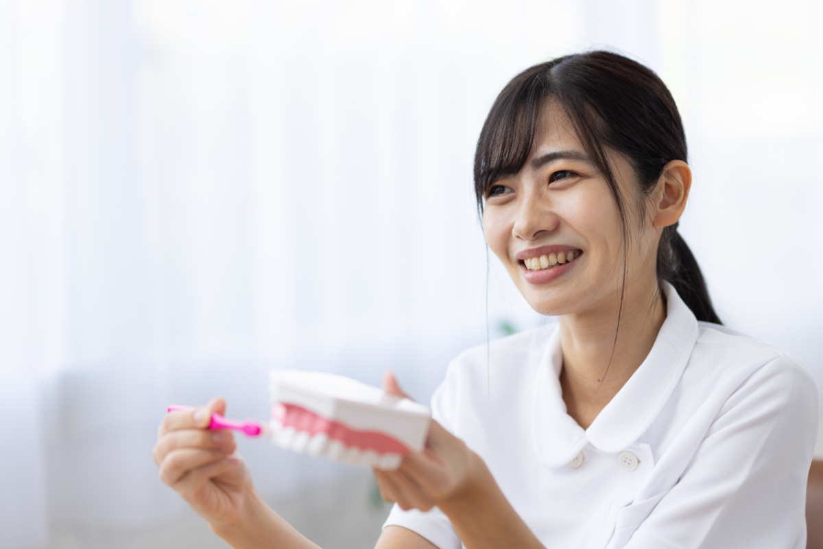 子どもにブラッシング指導している女性歯科医師