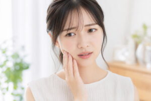 顎に痛みを感じる女性