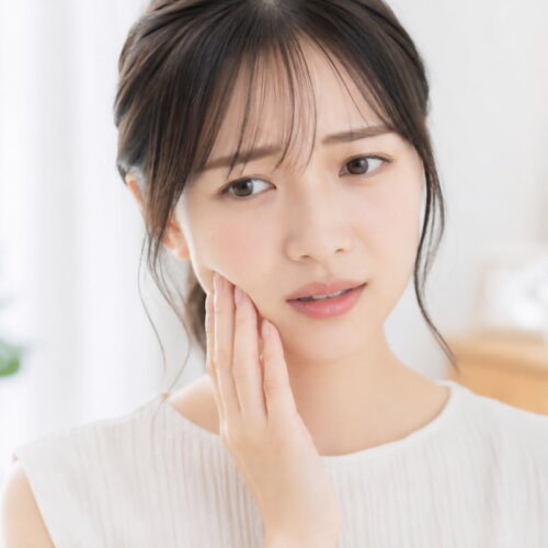 顎に痛みを感じる女性