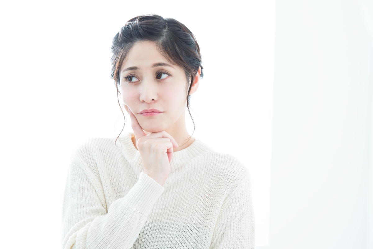 歯の根に膿が溜まることについて考える女性